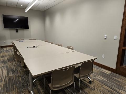 Room with tables, chairs, and tv